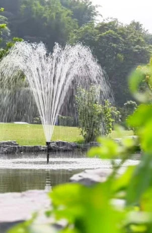 POPOSOAP pond fountain with LED lights creating a water display in a garden pond