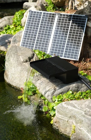 POPOSOAP solar waterfall kit beside a backyard pond