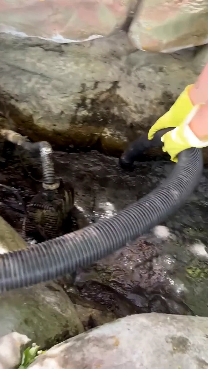 Close-up of garden water tubing between stones